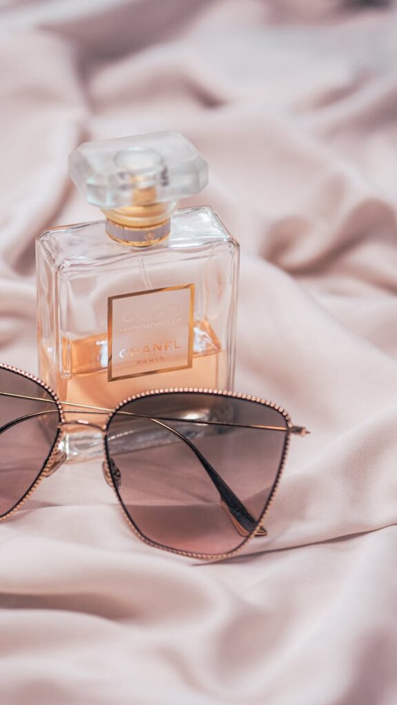 Crafting Captivating Headlines: Your awesome post title goes here Chanel perfume with stylish sunglasses on soft satin fabric, exuding elegance.