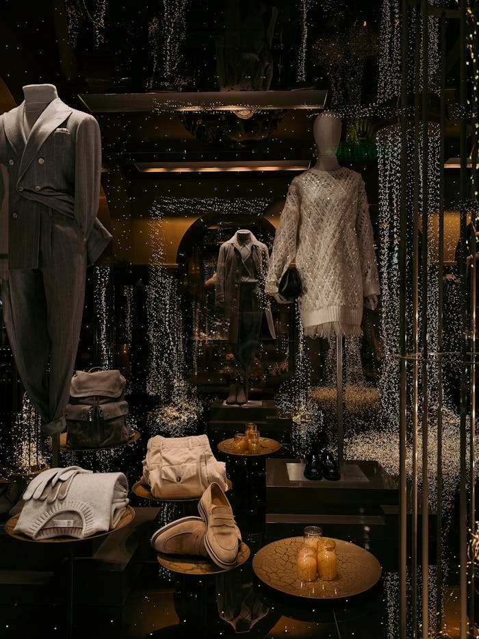 Luxurious fashion window display in Milan showcasing stylish outfits and accessories with a festive atmosphere.